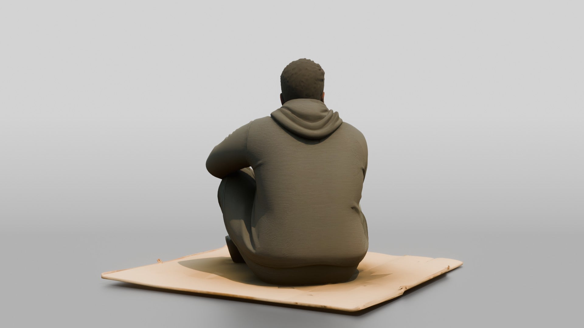 Homeless Man Sitting Flat on a Piece of Cardboard