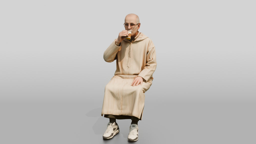 Elderly African Man in a Djellaba Sitting and Drinking Tea