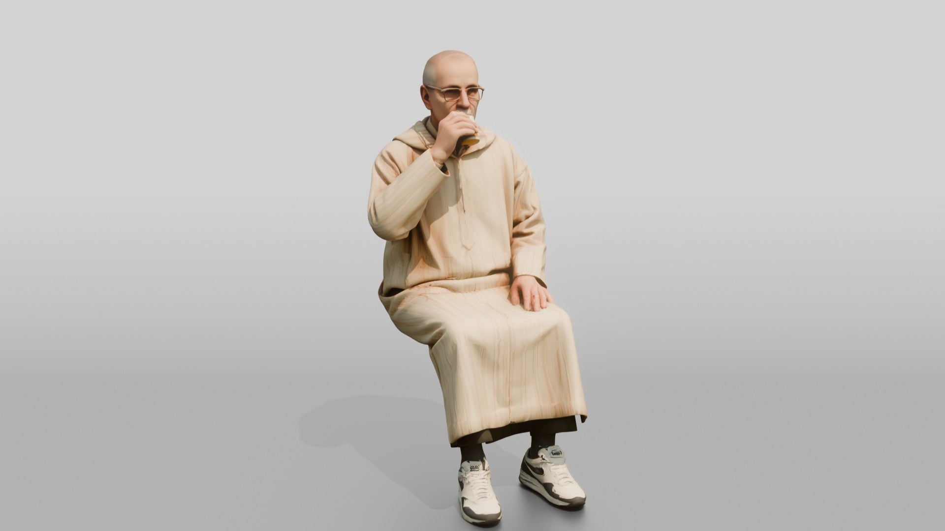Elderly African Man in a Djellaba Sitting and Drinking Tea