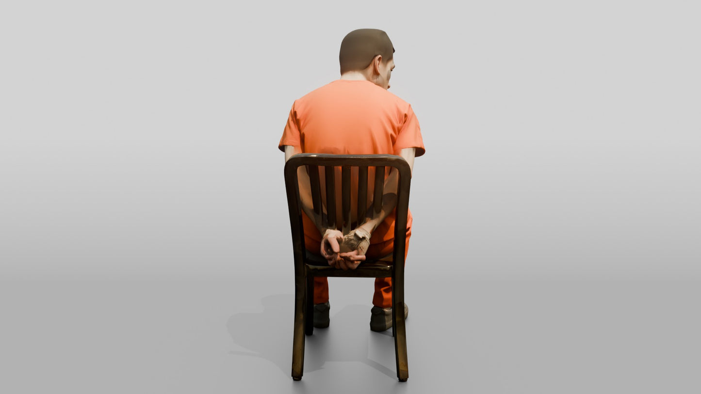 East Asian Male Prisoner Sitting Slouched in a Metal Chair