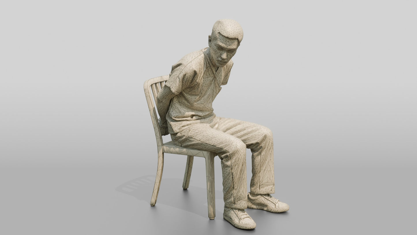 East Asian Male Prisoner Sitting Slouched in a Metal Chair