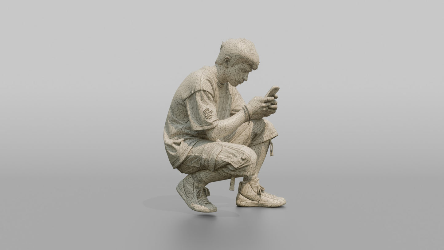 Teenage Boy Crouching to Look at His Phone