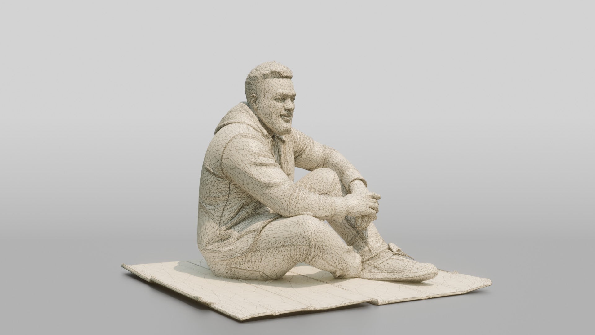 Homeless Man Sitting Flat on a Piece of Cardboard