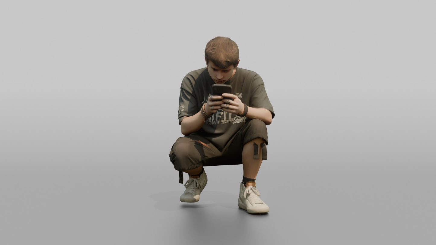 Teenage Boy Crouching to Look at His Phone