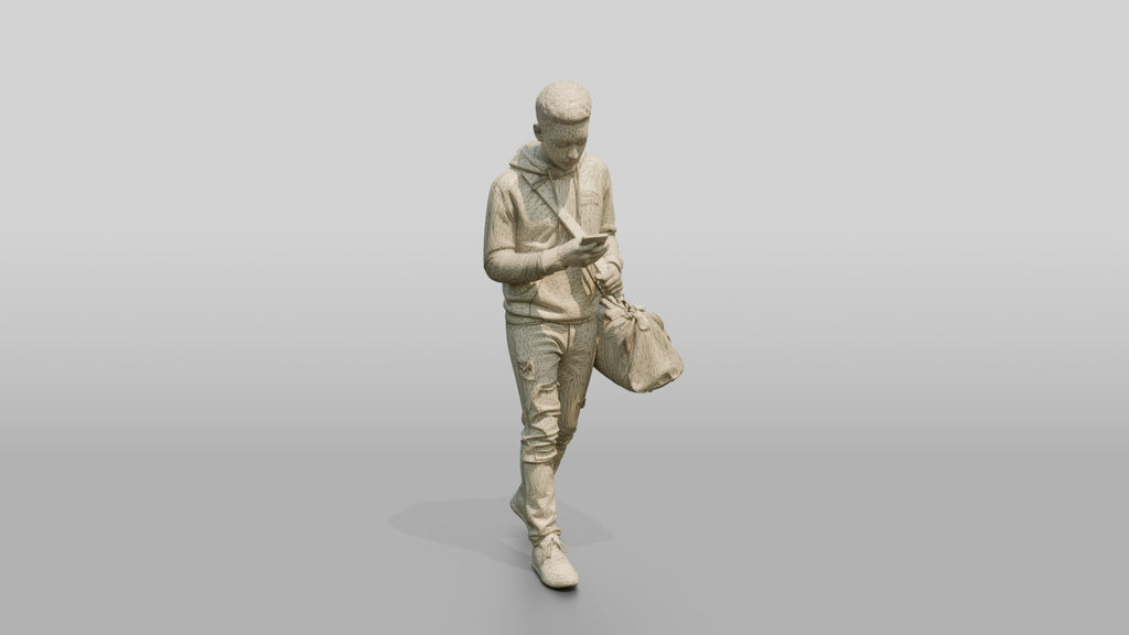 Young Black Man Walking and Looking at Phone with Duffel Bag